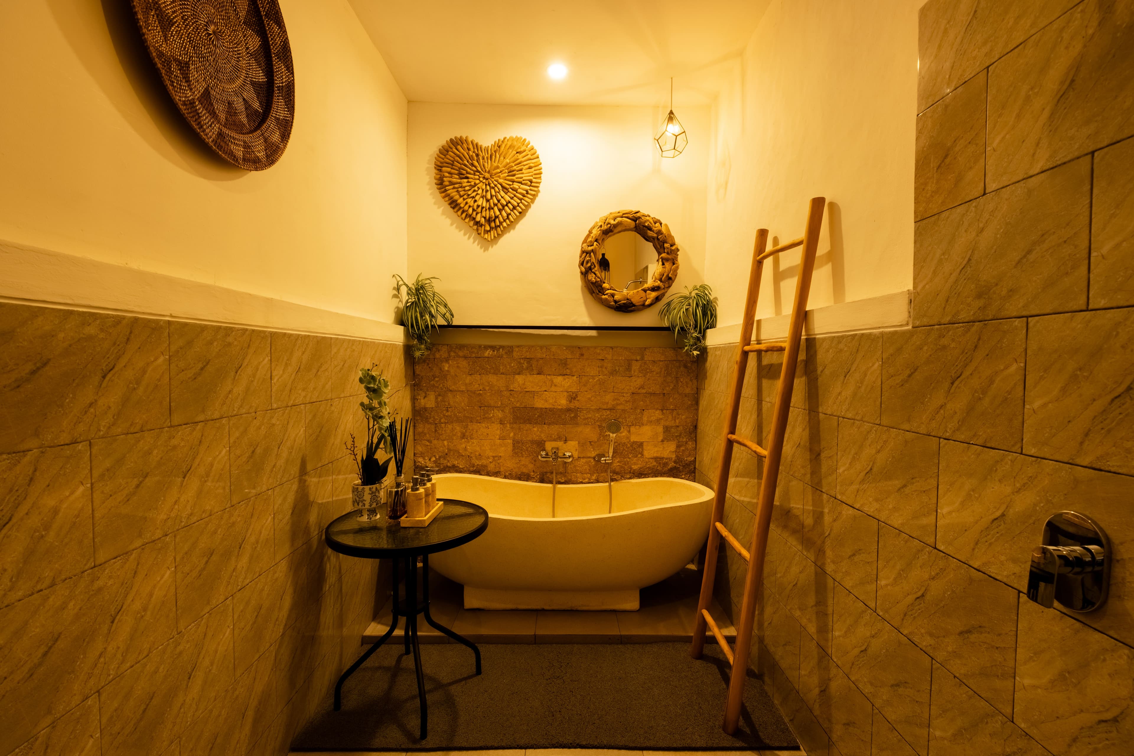 Private spa bathroom with a freestanding soaking tub, driftwood mirror and heart-shaped wall decor