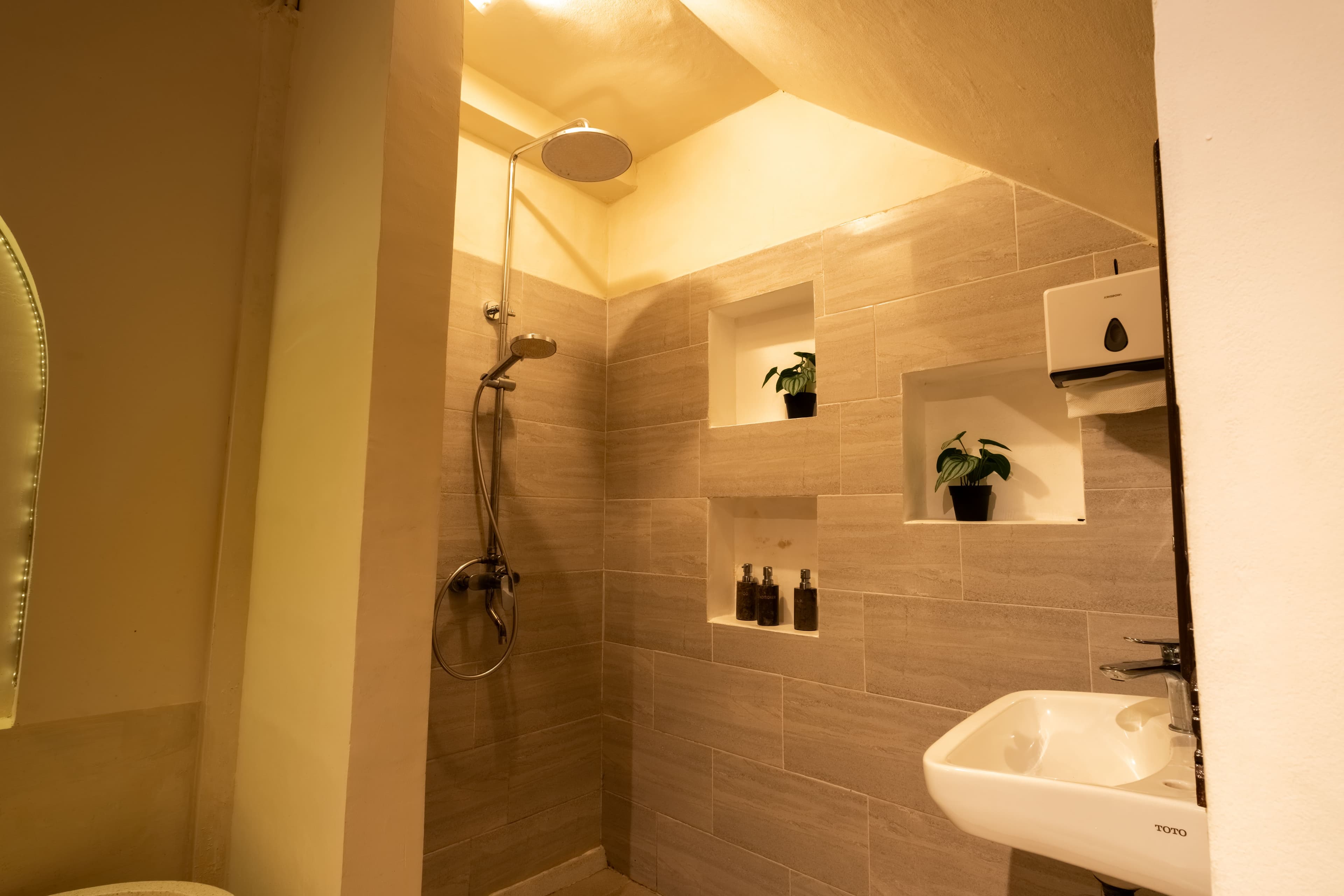 En-suite shower area with a rain showerhead and tiled display niches